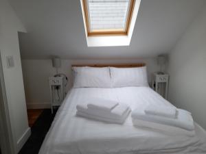 WhitecroftFig Cottage Holiday Home的一张白色的床,上面有三条毛巾