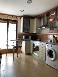 曼西利亚德拉斯穆拉斯Casa Mino的厨房配有桌子和洗衣机。