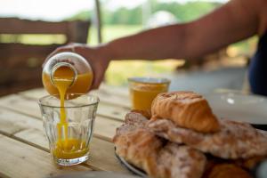 费克纳姆Wild Meadow, Lodge Farm, East Raynham的一张桌子,上面放着一盘面包和橙汁