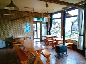 藏王温泉Matsuo House - Max 4 person Room Natsu的餐厅设有木桌、长凳和窗户。