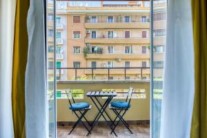 罗马SAPIENZA Grand Apartment的一个带桌椅的阳台和一座建筑