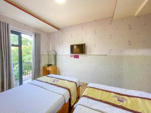 Liên Trì (4)Khách sạn Triều Dâng的客房设有两张床和一台墙上的电视。
