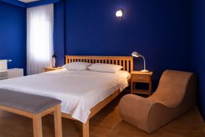 普里什蒂纳Artament Prishtina的蓝色卧室,配有床和椅子