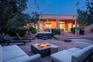 塞多纳Amazing Luxury Home with Hot Tub & Views的房屋前设有带沙发和火坑的庭院