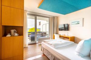 施坦贝尔格湖畔贝格莱尼赛酒店的一间卧室配有一张蓝色天花板的床