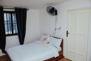 阿克拉William Ofori-Atta Fie的卧室配有白色的床和窗户。