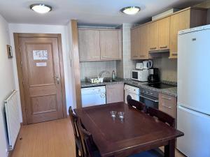索尔德乌Pleta 214的厨房配有木桌、椅子和冰箱