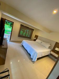 蒙特内哥罗Hotel Campestre Santa Lucia的一间卧室设有一张大床和一个窗户。