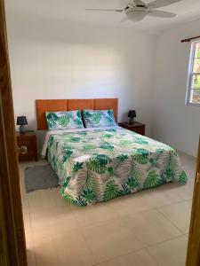 格罗斯岛Kay Nou Apartments的一间卧室配有一张带绿色和白色棉被的床