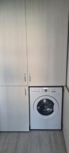 GherlaSofia Apartments的一个带橱柜的洗衣机和烘干机