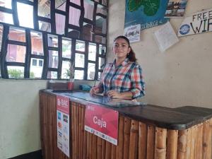 BalgueHostal Así es mi Tierra的女人站在木柜台上