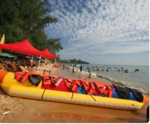 Kampong Tanah Merahseaview studio ocean view resort的一条在海滩上与水中的人一起航行的巨船