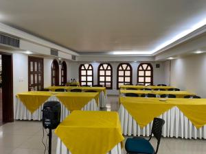 库库塔Hotel Faranda Bolivar Cucuta, a member of Radisson Individuals的配有桌椅和黄桌罩的房间