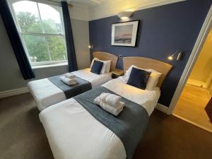 惠特比乔治酒店 的蓝色墙壁客房的两张床