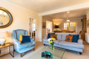 Saint ClementFinest Retreats - Tideway的客厅配有2把蓝色椅子和1张沙发