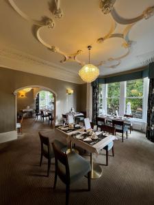 哈罗盖特Ascot House的一间带桌椅和吊灯的用餐室
