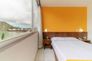 维多利亚Alice Vitoria Hotel By Nobile的一间卧室设有一张床和一个大窗户