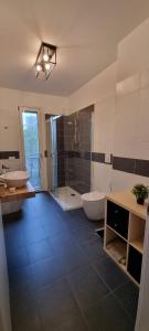 米兰La maison de Florina的浴室配有2个盥洗盆、浴缸和淋浴。