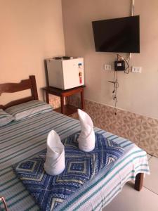 卡罗莱纳Pousada Vidal的酒店客房带两张床,上面有白鞋