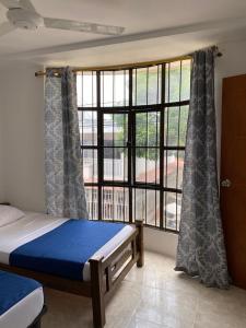 圣玛尔塔Apartamento con aire acondicionado y parqueadero por dias en Santa Marta的一间卧室设有一张床和一个大窗户