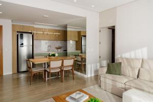 格拉玛多304/2 apto com piscina aquecida的厨房以及带桌子和沙发的客厅。