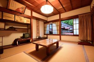 高野山高野山 宿坊 大明王院 -Koyasan Shukubo Daimyououin-的客厅配有木桌和电视。