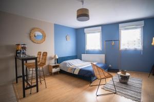 圣纳泽尔L'Effet-Mer - Tout équipé - Parking Privé - Wifi的卧室拥有蓝色的墙壁,配有一张床和椅子