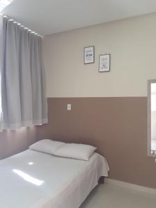 邦热苏斯-达拉帕Center Prime Hotel的卧室配有白色的床和窗户。