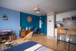 圣纳泽尔L'Effet-Mer - Tout équipé - Parking Privé - Wifi的客厅设有蓝色的墙壁和椅子,厨房