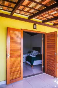 卡皮托利乌Pousada Enseada da Ilha的通往卧室的开放式门,卧室配有床