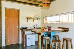 普腊亚罗萨Moradas do Vale Praia do Rosa的一间厨房,内设一个柜台和凳子
