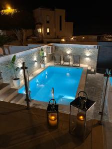 阿德耶Luxury house Atlantico private heated pool的夜间大型蓝色游泳池,灯光照亮