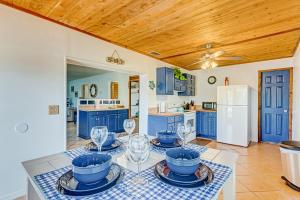 维洛海滩Sunshine Escape的厨房配有蓝色橱柜和酒杯桌子