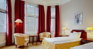 哈诺桑德第一施塔特酒店的酒店客房,设有两张床和红色窗帘