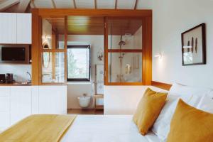 阿马兰特Oliveiras Village — Agroturismo的一间带白色床的卧室和一间浴室