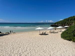 宫古岛BiBi Hotel 宮古空港前的海滩上设有遮阳伞和椅子,还有大海