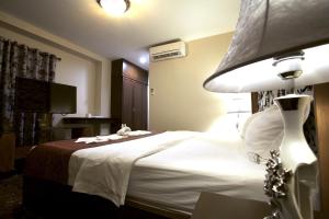 芭堤雅市中心卡特斯里楼酒店的酒店客房,配有床和灯