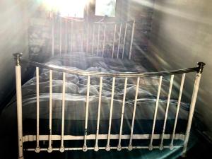 霍姆弗斯The Writers Cottage - Intriguing & Romantic的一张带床的房间里装有金属床的婴儿床