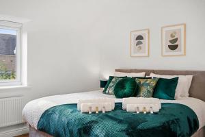 达特福德Townhouse in Dartford sleeps 8 with free parking的一间卧室配有一张带绿色枕头的床和一扇窗户