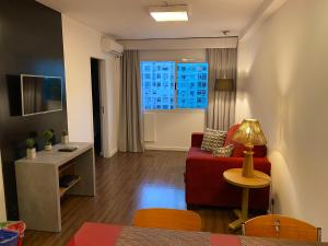 里约热内卢Flat Ipanema 2 Quadras da Praia - Estacionamento gratuito的客厅配有红色的沙发和桌子