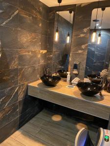 汉堡OLÉ Hotel的浴室设有2个水槽和2面镜子
