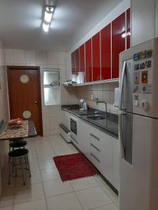 圣若阿金Apê aconchegante e quentinho em São Joaquim的厨房配有白色家电和红色橱柜