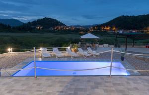 普洛切Family friendly apartments with a swimming pool Bacina, Neretva Delta - Usce Neretve - 15309的一个带椅子的游泳池以及排球场