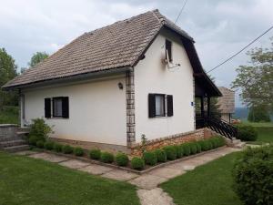 波利亚纳克Holiday house with a parking space Poljanak, Plitvice - 15340的黑色屋顶的白色房子