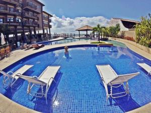 拉巴拉德纳圣米格尔Apartamento em Barra Bali, Resort de Luxo - Destino BSM 329的一个带椅子和水中一个女人的大型游泳池