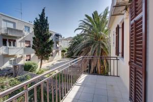木洛希尼Apartments by the sea Mali Losinj (Losinj) - 15576的阳台设有围栏和棕榈树