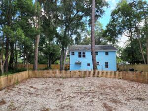 盖恩斯维尔Cozy Hideaway in the Duck Pond area of Gainesville的一座带栅栏的院子中的蓝色房子