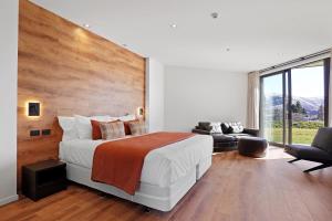 特卡波湖Grand Suites Lake Tekapo的一间卧室设有一张带木墙的大床
