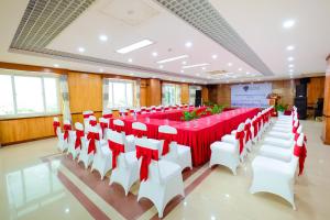 Phủ Lý卡斯桑因克515.9酒店的一个带红色和白色桌椅的大型宴会厅