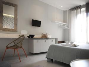 马纳罗拉卡迪安德烈酒店的一间卧室配有一张床、一把椅子和电视